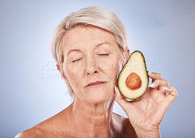 Buy stock photo Mature, beauty and skincare with a woman and an avocado for smooth, soft skin on a grey background. Anti aging, skin care facial treatment with fresh food for senior female with avo for health 
