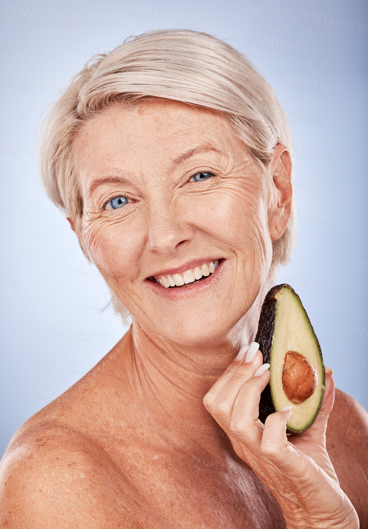 Buy stock photo Skincare, beauty and senior woman with avocado for health, wellness and diet against a grey studio background. Fruit, smile and face portrait of an elderly person with food for nutrition and body