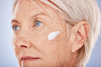 Buy stock photo Skincare, beauty and old woman with facial cream in studio posing for face and body care. Wellness, healthcare and senior female with sunscreen, lotion and antiaging skincare products for dermatology