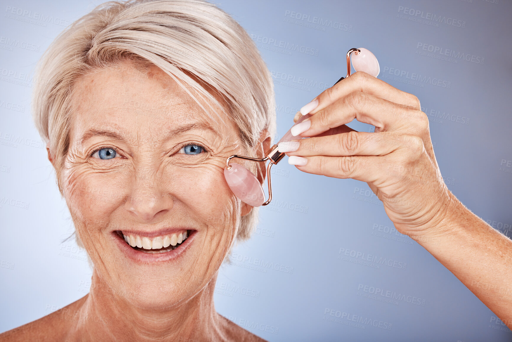 Buy stock photo Skincare, face roller and senior woman with a beauty, natural and fresh skin routine in a studio. Cosmetics, face and portrait of elderly lady with a facial tool doing a cosmetic anti aging treatment