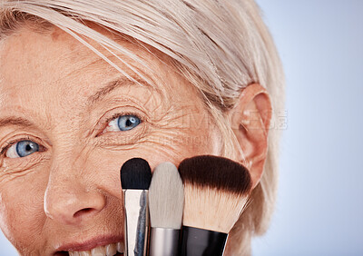 Buy stock photo Makeup, cosmetics and face of a senior woman with brushes against a grey studio background. Happy, smile and portrait of an elderly person with product for facial cosmetic skincare and beauty