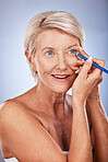 Beauty, makeup and eyeliner with a senior woman in studio on a gray background to apply cosmetics to her face. Eyes, product and luxury with a mature female applying a cosmetic with an eye pencil