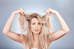 Hair, portrait and woman in studio for hair care, problem and  fail or hair loss against grey background. Confused, girl and model with split ends, dry and tangle, damaged hair and frizz with mockup