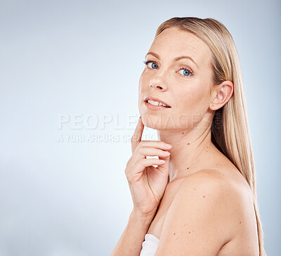Buy stock photo Face, beauty and skincare with a model woman in studio on a gray background with mockup for wellness. Portrait, luxury and cosmetics within attractive young female posing to promote natural care