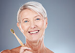 Dental, toothbrush and portrait of senior woman with teeth hygiene, wellness and health in studio. Cosmetic, clean and happy elderly woman with oral care to prevent cavity isolated by gray background