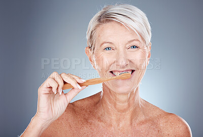 Mature woman, toothbrush and portrait for health, wellness and oral care on a grey studio background. Brushing teeth, clean and senior female cleaning her mouth for oral care or dental hygiene
