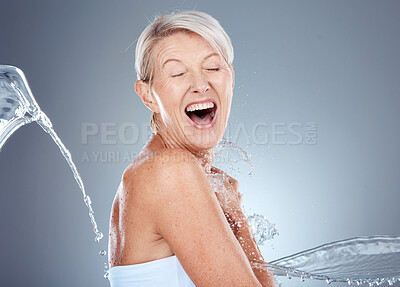 Buy stock photo Water splash, health and portrait of senior woman shocked and surprised on gray background. Skincare, wellness and beauty, a happy mature lady splashed with water with happy smile on face in studio.