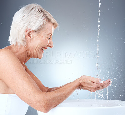 Buy stock photo Senior woman, water splash and cleaning hands in a basin for hygiene against a grey studio background with mockup space. Elderly model washing hand for, health, bacteria and clean body with liquid