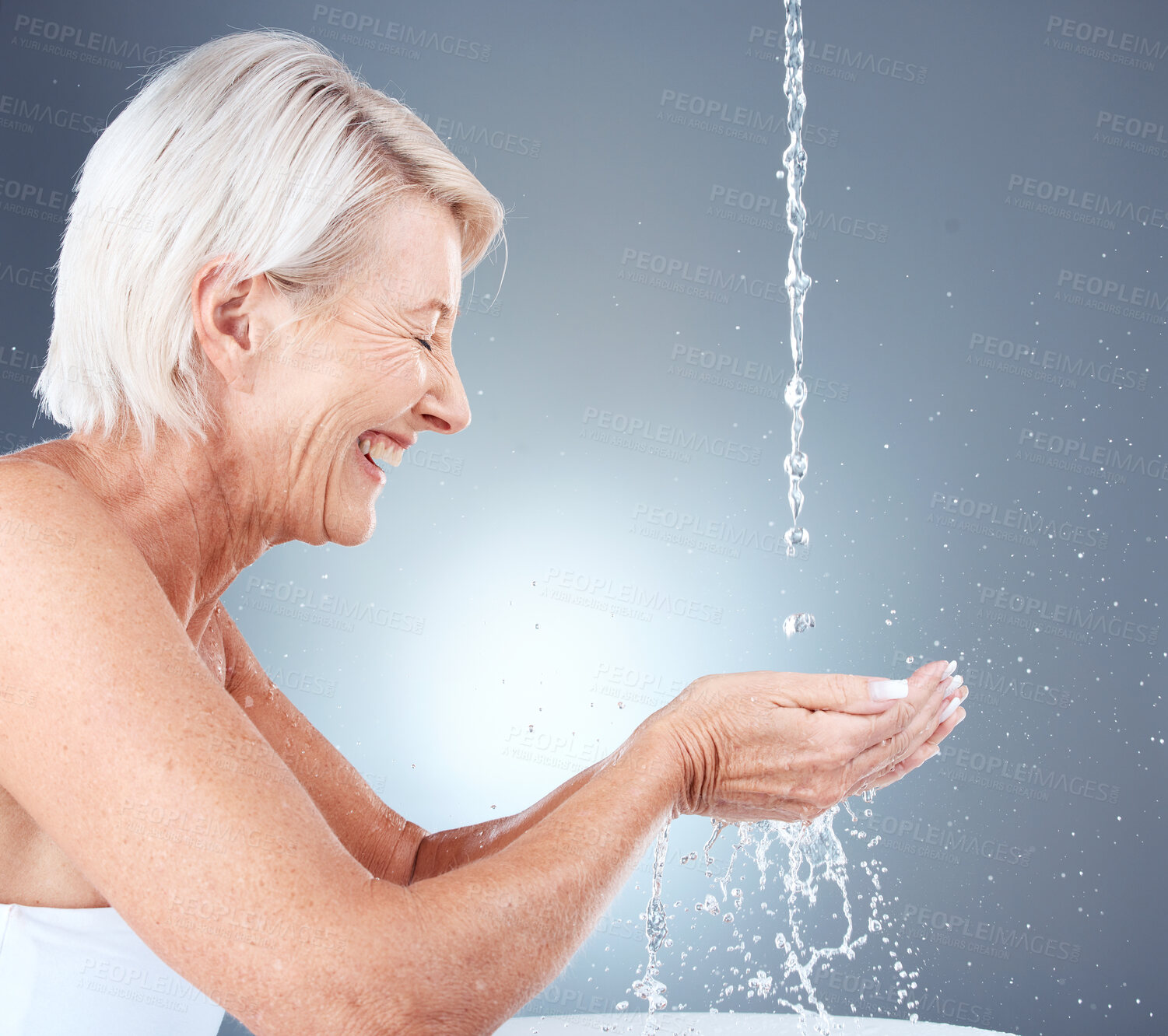 Buy stock photo Skincare, happy and senior woman with water for face, beauty and hydration against a grey studio background. Cleaning, wellness and elderly model with a smile for hygiene and grooming with liquid