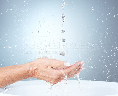 Buy stock photo Water splash, studio and woman cleaning hands in sink or basin on blue background with mockup. Hygiene, health and mature female model washing hands for wellness, skincare and safety from bacteria.