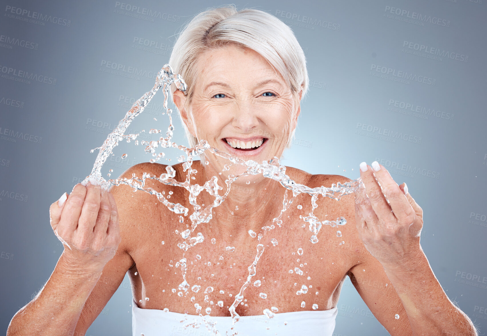 Buy stock photo Water splash, mature woman cleaning face on gradient background for health, beauty and skin care routine. Skincare, cosmetics and portrait of happy senior woman with smile washing in water in studio.
