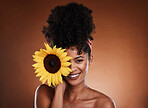 Beauty, skincare and portrait of model with sunflower for health, wellness or body care antioxidants. Facial cosmetics, natural makeup and face of black woman with vitamin e product for diy self care