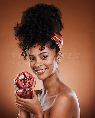 Buy stock photo Face, beauty and pomegranate with a black woman model in studio on a brown background for natural vitamins. Skincare, wellness and luxury with an attractive young female posing to promote nutrition