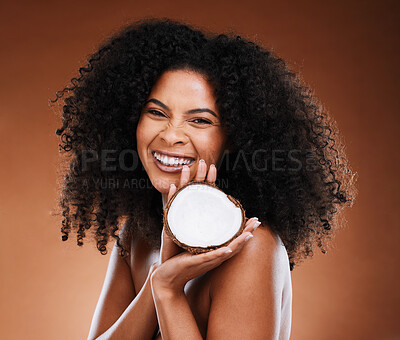 Buy stock photo Skincare, hair care and black woman marketing coconut for wellness of skin against a brown studio background. Advertising, cosmetics and face portrait of an African model with fruit for beauty