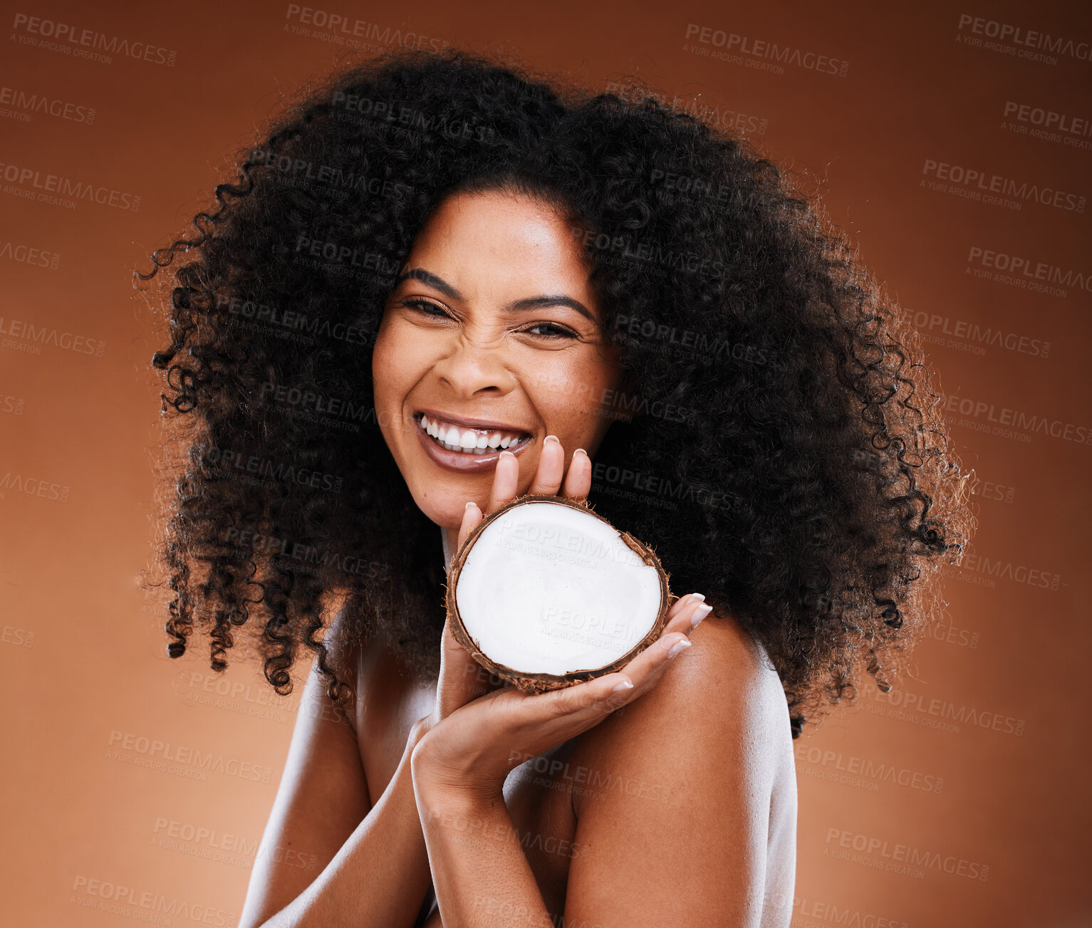 Buy stock photo Skincare, hair care and black woman marketing coconut for wellness of skin against a brown studio background. Advertising, cosmetics and face portrait of an African model with fruit for beauty