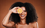Orange, skincare and beauty of a black woman holding health, vitamin c and healthy fruit. Portrait of a model with skin wellness, cosmetic eye treatment and diet food with a happy woman face 