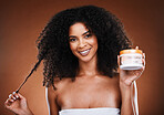 Hair care, advertising and portrait of a black woman with an afro and product against a brown studio background. Marketing, smile and face of an African model with a jar for healthy and happy hair