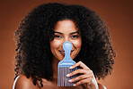 Beauty, hair care and portrait of black woman with comb for afro, natural and curly hair on brown background. Hair salon, cosmetics and girl with hair brush in hand for combing or grooming in studio