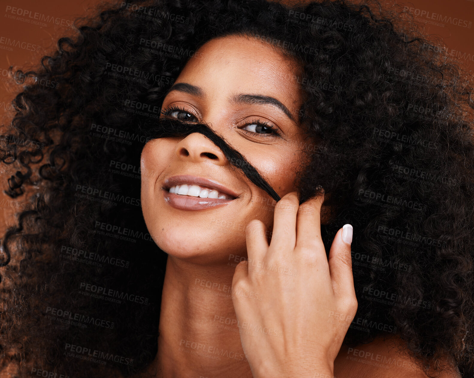 Buy stock photo Black woman afro, hand and smile for hair cosmetics, care or treatment against a studio background. Portrait of African American female model smiling with teeth in satisfaction for salon hairstyle