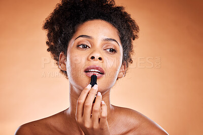 Buy stock photo Lipstick, black woman and cosmetics for smooth, glow and skincare with confidence with brown studio background.  Lips, African American female and girl with gloss, makeup and natural beauty for mouth