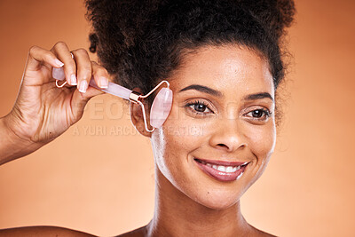 Buy stock photo Smile facial beauty, black woman with roller for happy wellness, aesthetic or health makeup, glowing skin on orange studio background. Girl, model or face massage for skincare cosmetics or healthcare