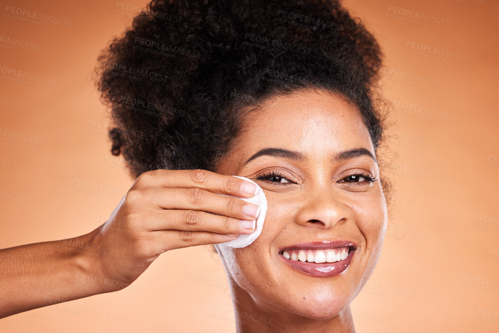 Buy stock photo Black woman, beauty and swab for makeup removal in skincare against a studio background. Portrait of African American female model smile removing facial cosmetics in satisfaction for skin treatment