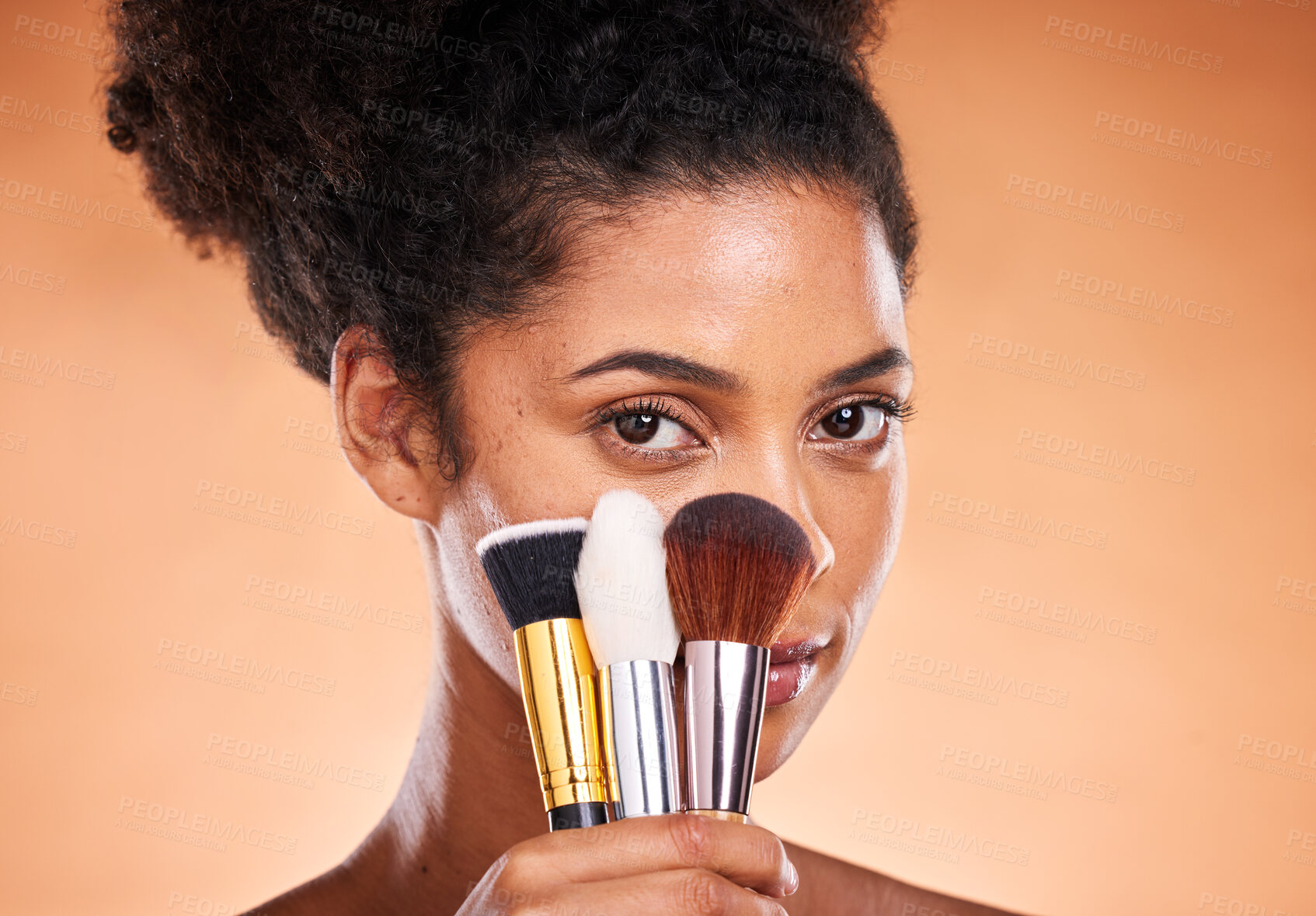 Buy stock photo Makeup, brushes and portrait of a black woman in a studio doing a beautiful, natural and cosmetic routine. Cosmetics, beauty and young female model with facial products isolated by orange background.