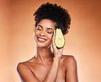 Skincare, wellness and black woman with avocado in studio on brown background for body care. Beauty, spa and female with vegetable for organic, natural and healthy beauty products and cosmetics