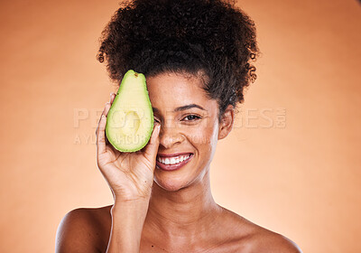 Buy stock photo Beauty, skincare and avocado with a model black woman in studio on a beige background for wellness or antioxidants. Portrait, skin or nutrition with an attractive young female proud of healthy eating