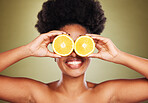 Skincare, beauty and happy woman with lemon in a studio for a natural, healthy and organic face routine. Cosmetics, citrus fruit and black model with a smile for facial treatment by green background.