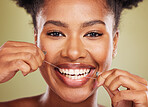 Floss, teeth and portrait of a black woman with dental, dentist and mouth wellness promotion in green studio. Young african model, tooth cleaning product and dental floss for healthcare advertising