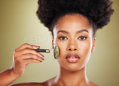 Buy stock photo Skincare, face roller and black woman in studio portrait with facial massage for natural beauty, cosmetics and facial wellness product. African beauty model with stone rose quartz in dermatology care