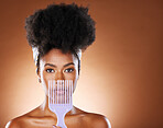 Black woman, hair care beauty or model with afro comb in studio with brown background portrait. Health salon, luxury wellness or African American girl for natural curly hair healthcare and a brush