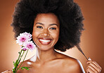 Flower, beauty and skincare of a black woman portrait with skin glow and hair care wellness. Woman model happy about natural, luxury and cosmetic beauty with a smile and flowers for facial treatment