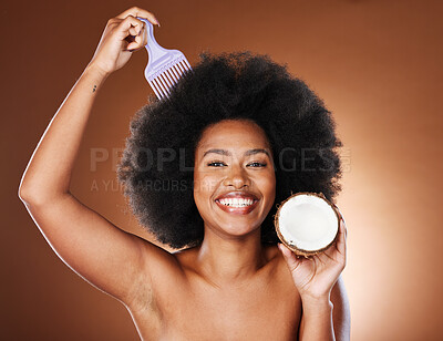 Buy stock photo Black woman, hair care comb and coconut for beauty in studio isolated on brown background. Wellness, healthy and female model with tropical fruit and coconut oil for hair style or afro hair treatment