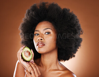 Buy stock photo Avocado, black woman and skincare beauty for cosmetics, moisturizer or nutrition in brown studio background. Portrait of African American female holding fruit with diet for healthy facial treatment
