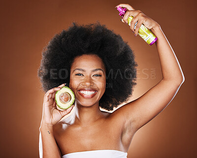 Buy stock photo Black woman, hair care and spray with avocado, afro glow and care, smile and cosmetic product in brown studio background. Fruit, natural cosmetics and happy model smile for beauty for head nutrition