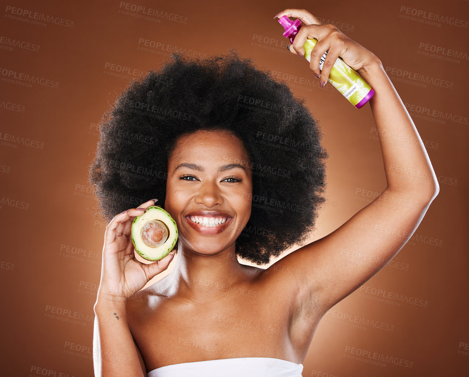 Buy stock photo Black woman, hair care and spray with avocado, afro glow and care, smile and cosmetic product in brown studio background. Fruit, natural cosmetics and happy model smile for beauty for head nutrition