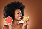 Grapefruit, black woman and vitamin c beauty, skincare and wellness, healthy body or aesthetics, natural cosmetics and afro on studio background. Happy young african model eating citrus for nutrition