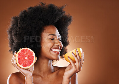 Buy stock photo Grapefruit, black woman and vitamin c beauty, skincare and wellness, healthy body or aesthetics, natural cosmetics and afro on studio background. Happy young african model eating citrus for nutrition
