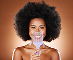 Black woman afro, comb and smile for hair care, style or fashion against a studio background. Portrait of African American female smiling in satisfaction for beauty hairstyle or salon treatment