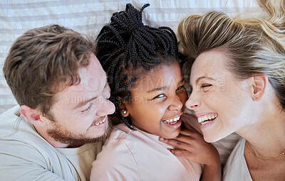 Buy stock photo Family, love and bed fun of a mom, dad and adopted girl laughing with a funny time at home. Portrait of a interracial child with mama and father smile bonding with parent care in a house bedroom