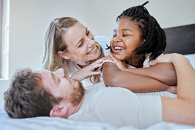 Buy stock photo Relax, adoption and diversity with family in bedroom for happy, support and bonding in the morning. Wake up, smile and playing with foster care child and parents at home for affection, trust or funny