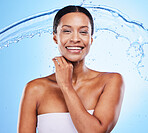 Black woman, water splash and shower with smile, cleaning body and skin hydration for wellness in blue studio background. Female model fresh and healthy skincare with treatment and healthy cosmetic