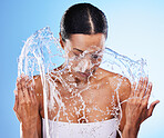 Skincare, water splash and black woman, cleaning and wash face, body and skin in blue studio background with 
 mockup. Beauty model with liquid in hands for facial cosmetic washing, wet and bathroom