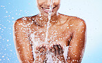 Woman hands, water splash and clean beauty, skincare and personal hygiene, wellness or shower on studio blue background. Closeup water drops, stream and washing hands for hydration, cleaning and body