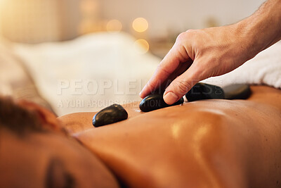 Buy stock photo Hand, rock or massage in spa to relax for zen, meditation or wellness physical therapy reiki in resort. Beauty, salon or woman for luxury healthcare, therapy or zoom of hot rocks for energy peace