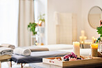 Candle, spa and relax with aromatherapy treatment in a tray in a room for luxury or wellness. Background, health and massage with still life in an empty resort for peace, skincare or relaxation