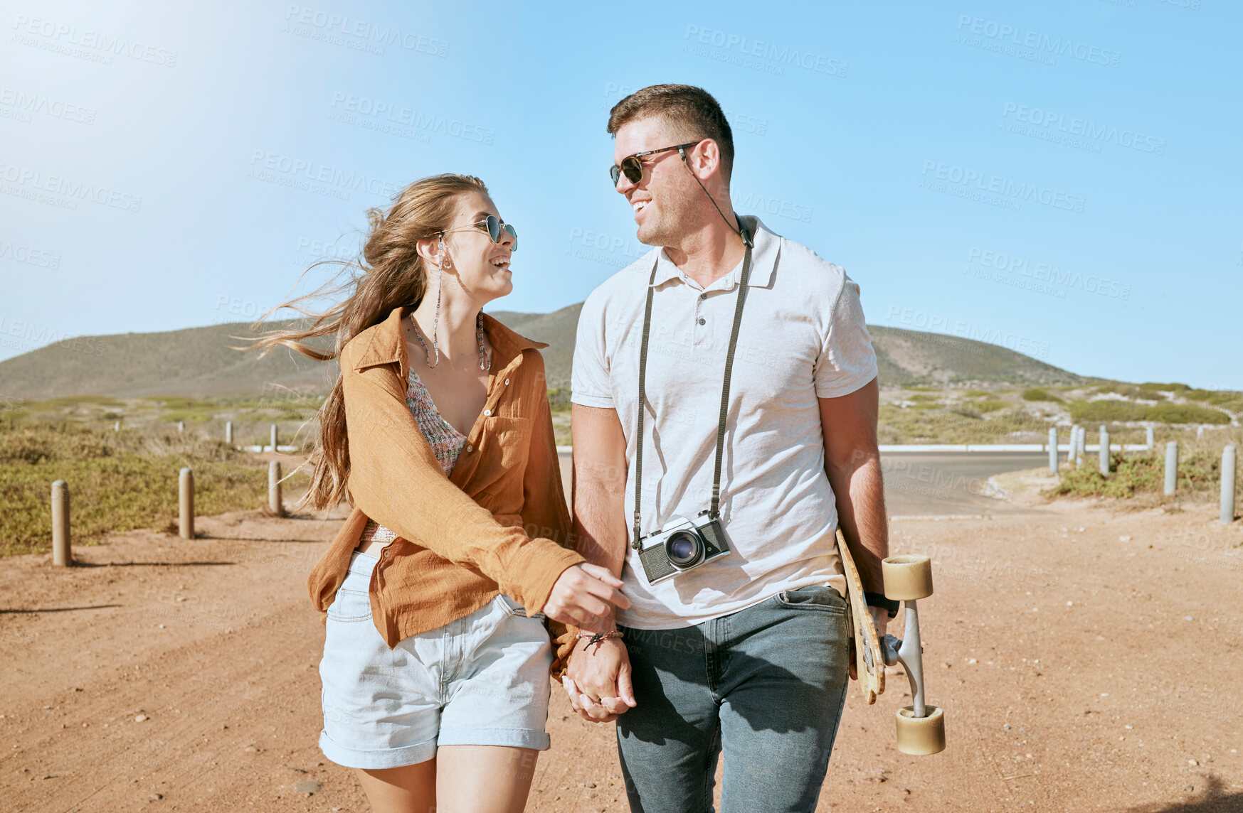 Buy stock photo Summer, love and skateboard with a couple walking outdoor in nature together during summer for romance. Holding hands, mountain and nature with a man and woman skateboarder bonding on a walk outside