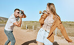 Photo, skateboard and couple on a road trip in nature to travel together during summer. Photographer, love and man with a vintage camera and picture of a woman ready for skateboarding in countryside